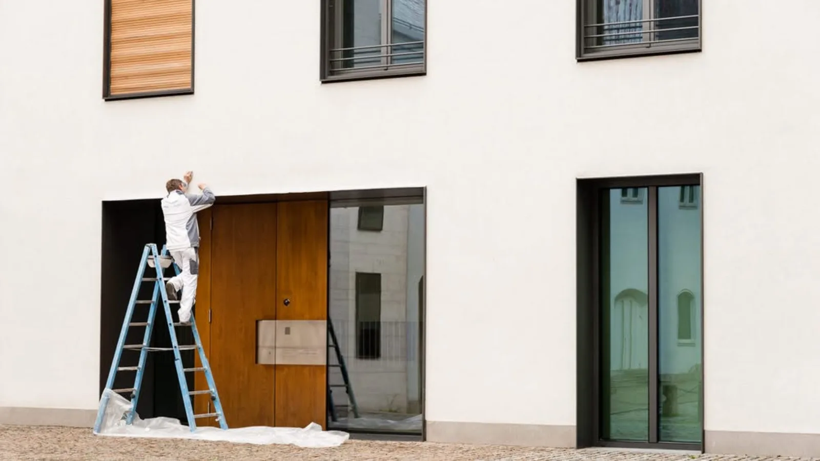 Painter working on a modern commercial building entrance